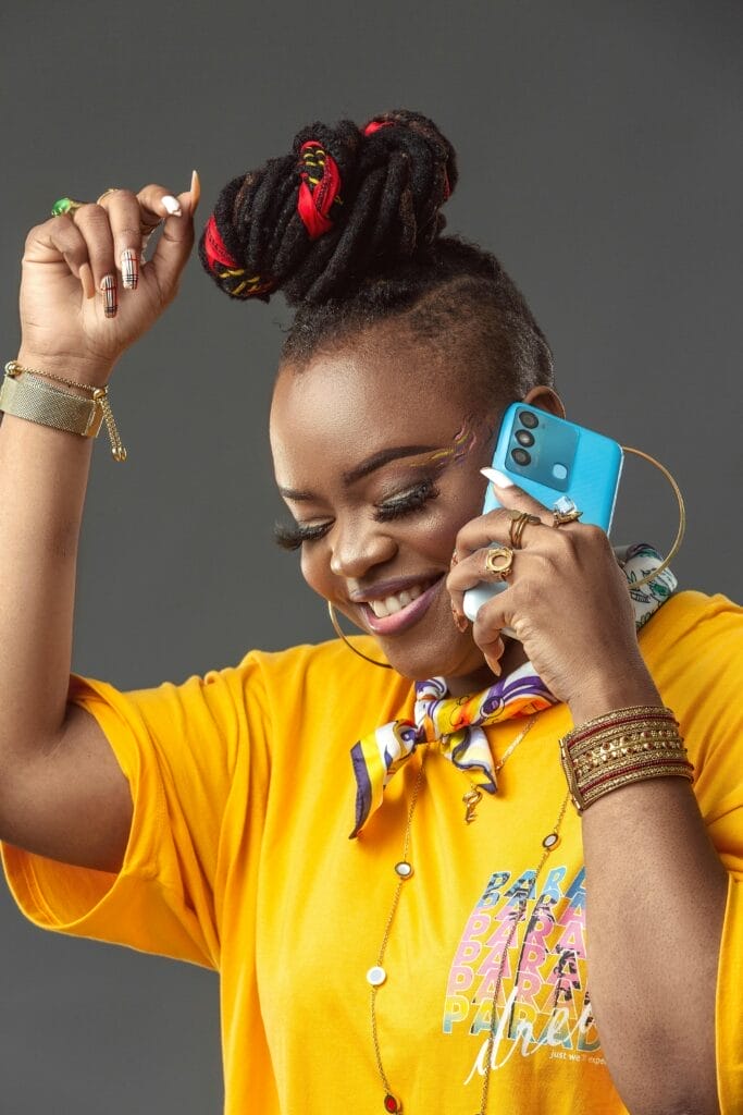 pexels-photo-14126954-14126954 Smiling woman in yellow fashion with phone, showcasing lively style and energy.
